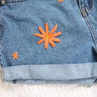 A close up of the big orange embroidered flower