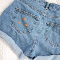 3 small embroidered orange flowers on the back pocket
