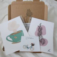 Close up of the letterbox mystery featuring a teacup print, rosemary print and flower basket bike sticker