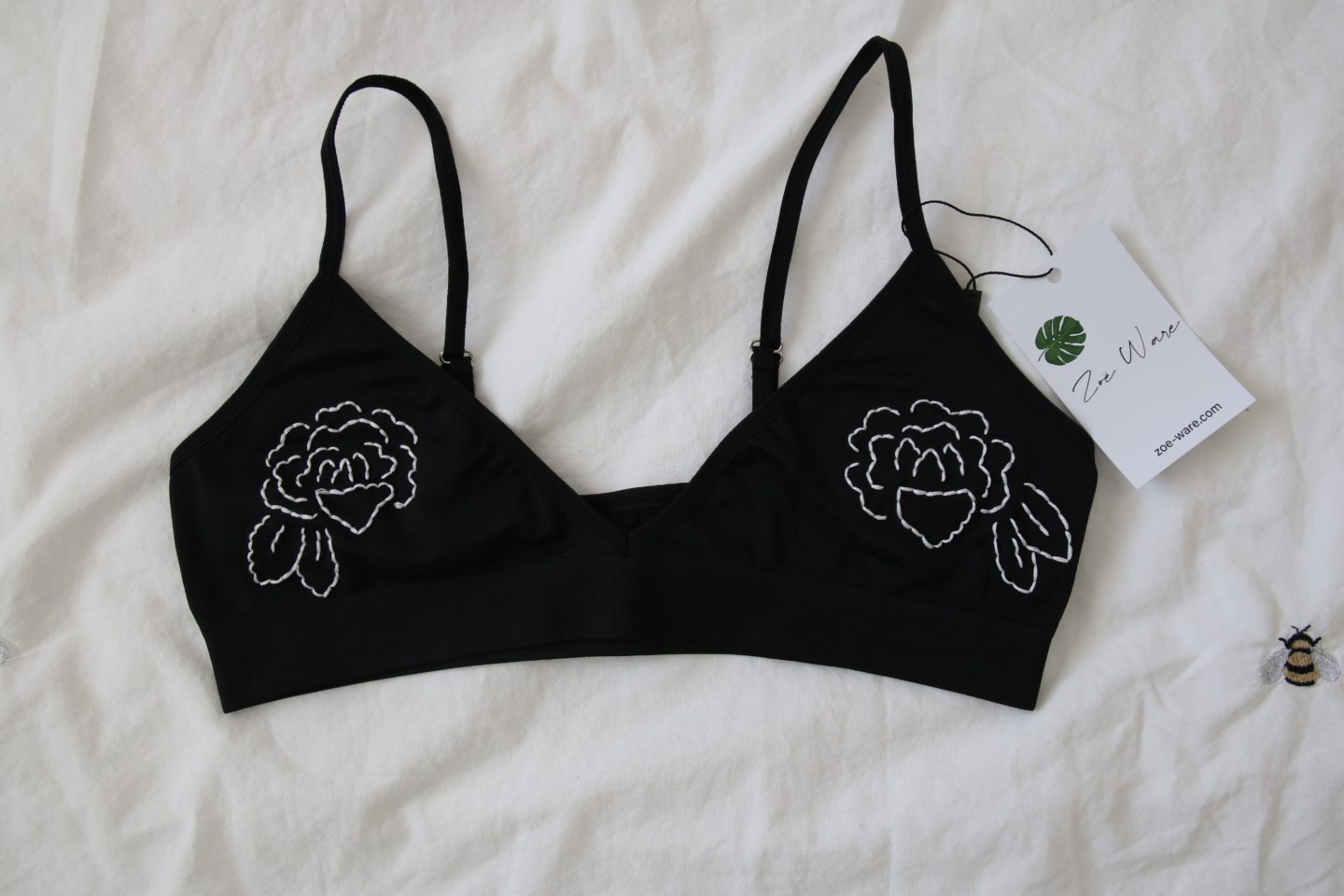 close up of black bralette hand embroidered with white roses