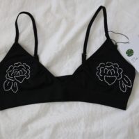 close up of black bralette hand embroidered with white roses