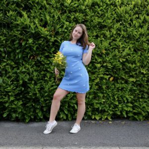brunette girl wearing a blue hand embroidered daisy dress