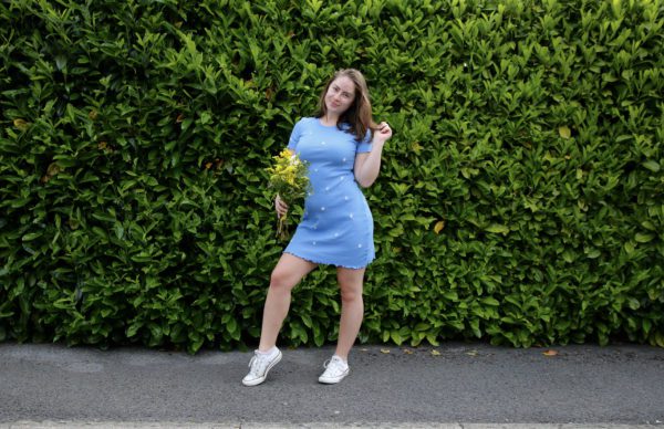 brunette girl wearing a blue hand embroidered daisy dress