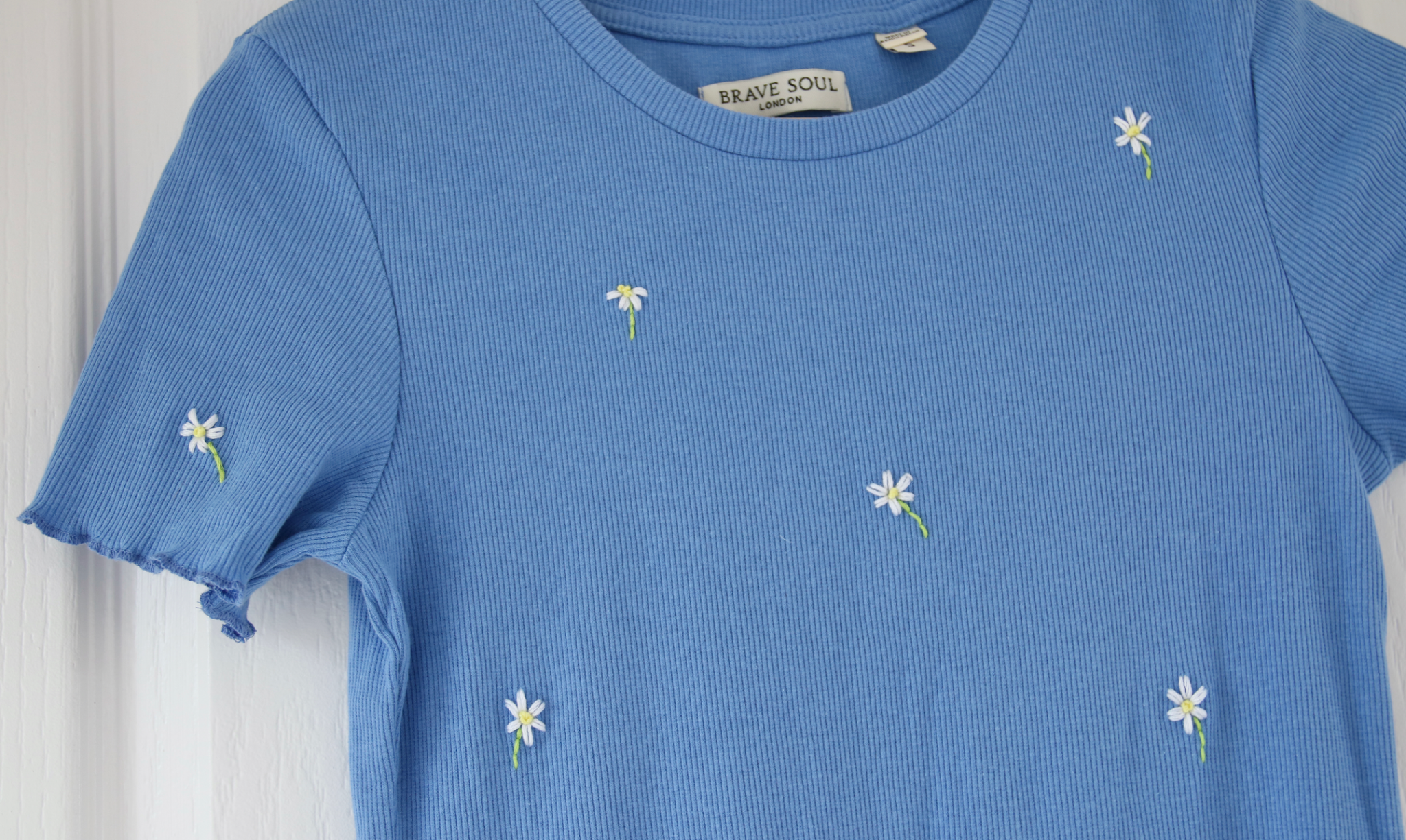 White daisies embroidered onto a blue body con dress