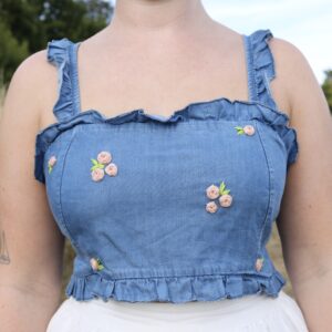 A blue denim crop top hand embroidered with pink roses