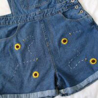Close up of the shorts showing hand embroidered sunflowers and bees