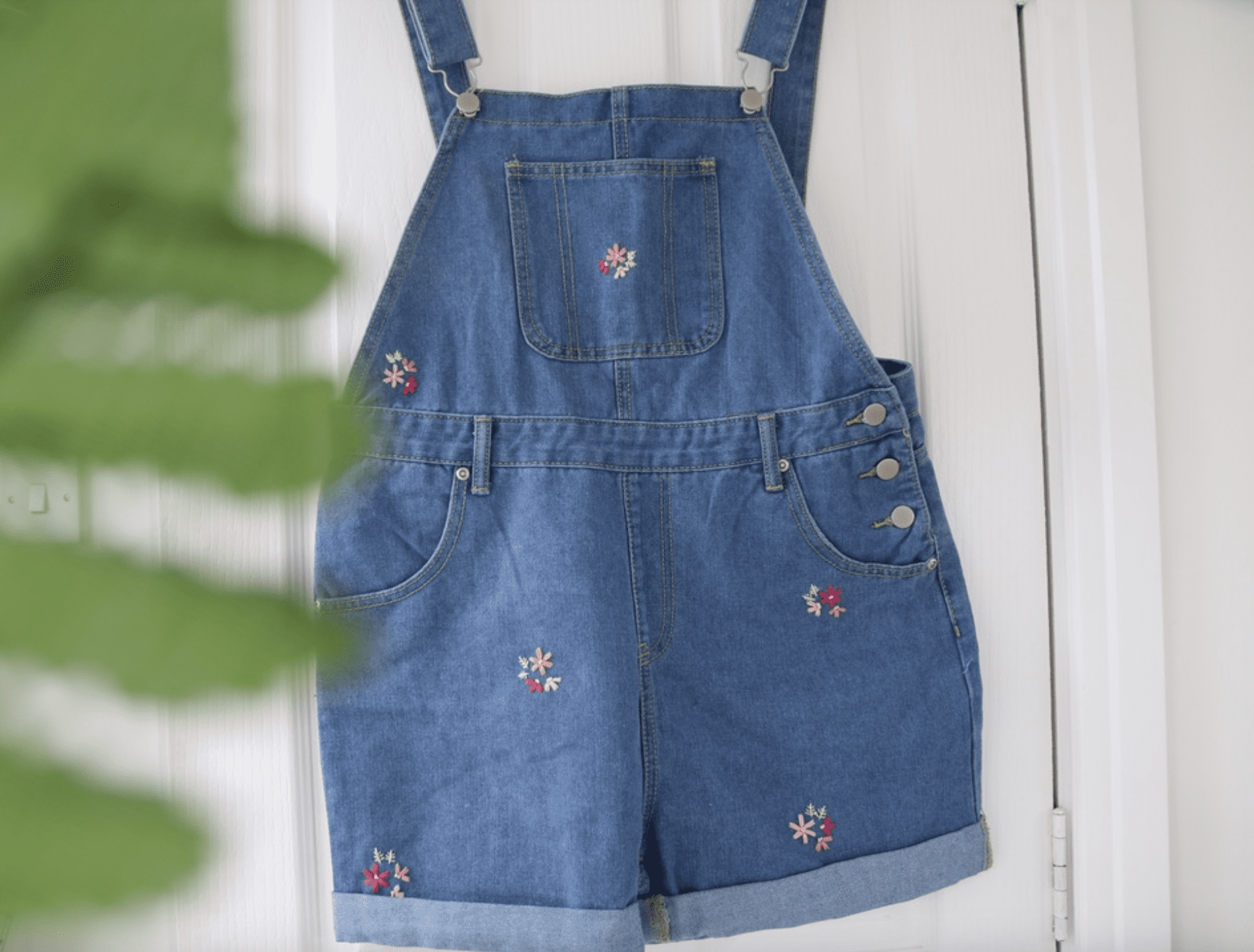 Blue denim overall shorts hand embroidered with pink scattered blossom