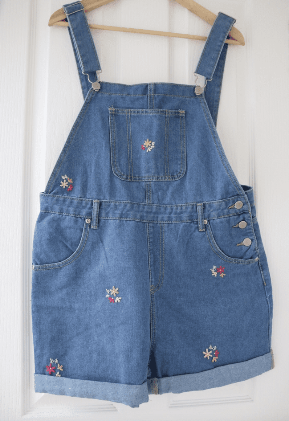 Blue denim overall shorts hand embroidered with pink scattered blossom