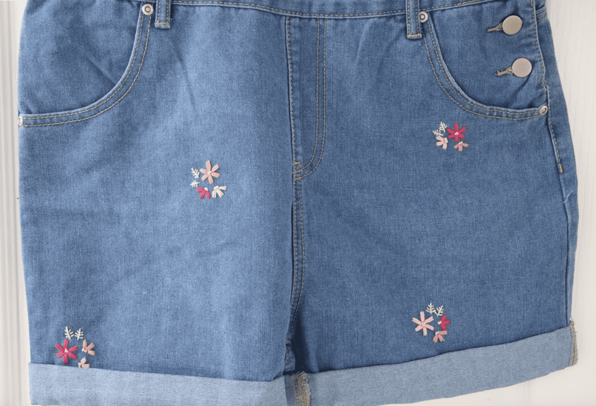 The shorts of blue overall shorts hand embroidered with pink blossom
