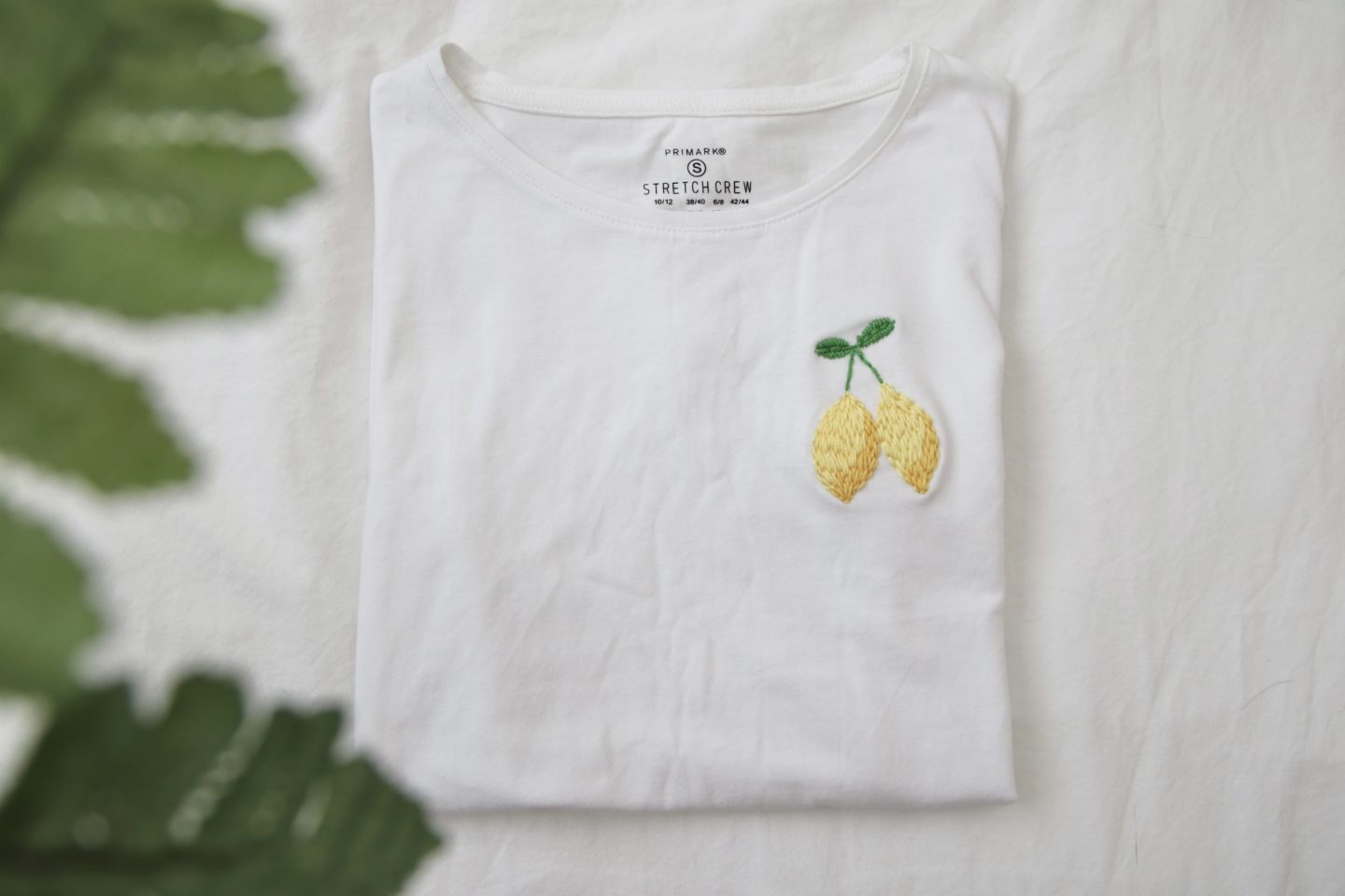 a white t-shirt with 2 hand embroidered lemons on the left breast