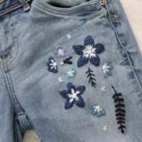 Close up of the blue floral embroidery stitch work on the blue skinny jeans