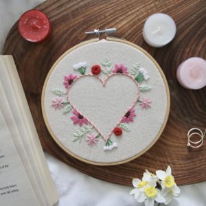 Embroidered heart surrounded by wildflowers