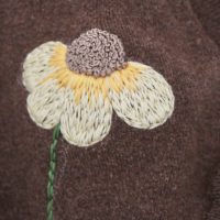 close up of hand embroidered calendula flower