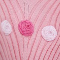 close up of 3 hand embroidered pink roses