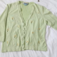 flatlay photo of pale green cardigan embroidered with sunflowers