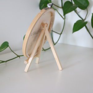 Back view of wooden embroidery hoop stand holding an embroidery hoop