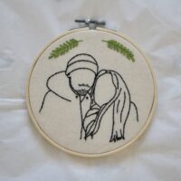 A 6 inch embroidery hoop hand embroidered with the outline of a boyfriend and girlfriend