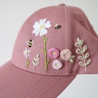 close up of the embroidery on the cap. Flowers, bees, leaves