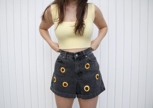 close up of girl wearing sunflower shorts and yellow top