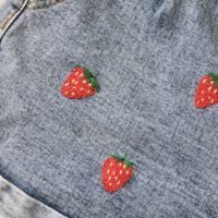 a close up of hand embroidered red strawberries