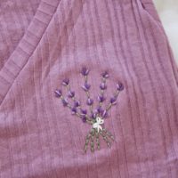 Close up of a hand embroidered lavender bouquet, tied in a bow