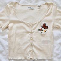 cream crop top hand embroidered with an orange monarch butterfly and flowers