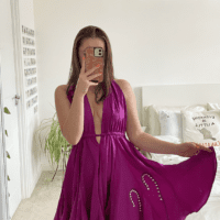 brunette model wearing a purple halter neck dress hand embroidered with white lily of the valley flowers