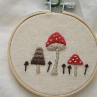 Close up of hand embroidered toadstool mushroom and fungi