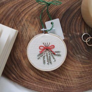 Christmas tree decoration hand embroidered with mistletoe tied with ribbon