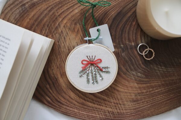 Christmas tree decoration hand embroidered with mistletoe tied with ribbon