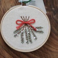 close up of hand embroidered mistletoe