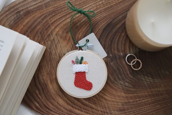 christmas tree decoration hand embroidered with a red stocking and presents spilling out the top