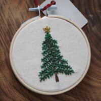 Close up of a hand embroidered tree topped with a gold star