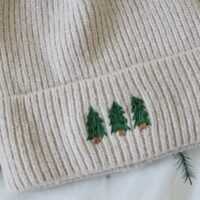 close up of 3 hand embroidered evergreen trees