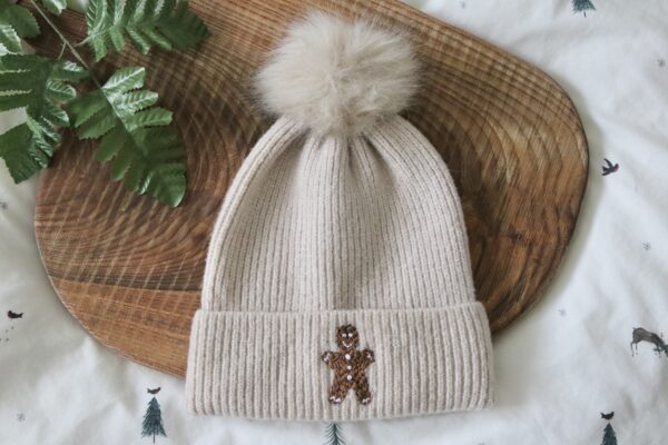 Cream beanie hand embroidered with a gingerbread man