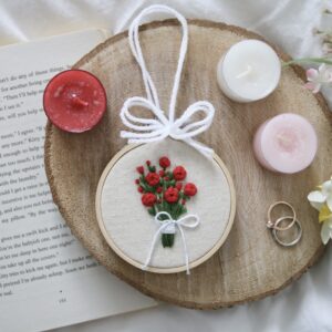 A 3 inch bamboo hoop with a hand embroidered bouquet of red roses