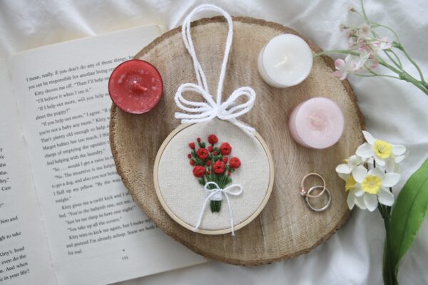 A 3 inch bamboo hoop with a hand embroidered bouquet of red roses