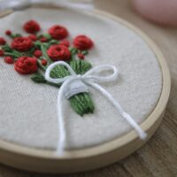 Red rose bouquet tied with ribbon hand embroidered into a 3 inch hoop