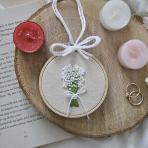 A three inch embroidery hoop hand embroidered with a gypsophila bouquet of flowers