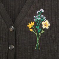 Hand embroidered bouquet of flowers in shades of orange, yellow and white on a khaki cardigan