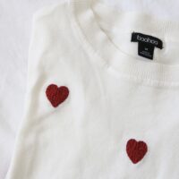 Hand embroidered red hearts on a white jumper