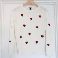 A white jumper hand embroidered with red love hearts all over