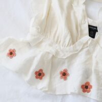 Hand embroidered pink cherry blossom on a white top
