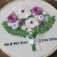 Intricate hand embroidered stitches of purple flowers