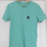 A long blue tee hand embroidered with a navy blue sailboat on the left breast