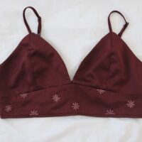 A deep red wine coloured bralette hand embroidered with dusty red hued flowers