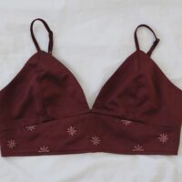 A deep red wine coloured bralette hand embroidered with dusty red hued flowers