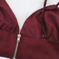 A silver zipped back to a dark red coloured bralette