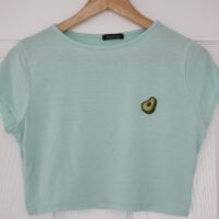 A mint blue t-shirt hand embroidered with an avocado slice