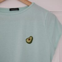 A mint blue t-shirt hand embroidered with an avocado slice